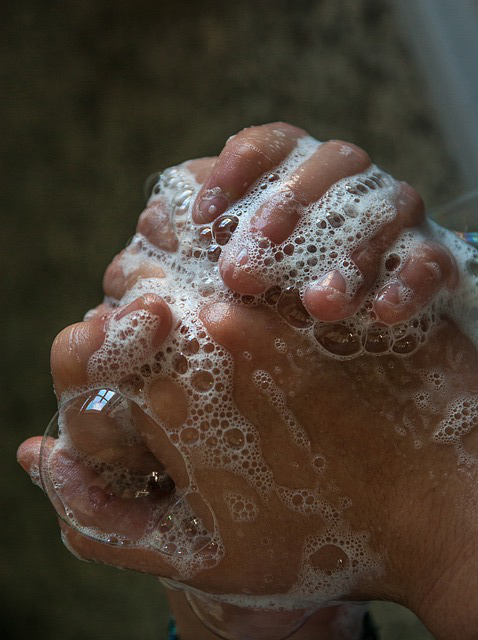 Soapy hands being washed.