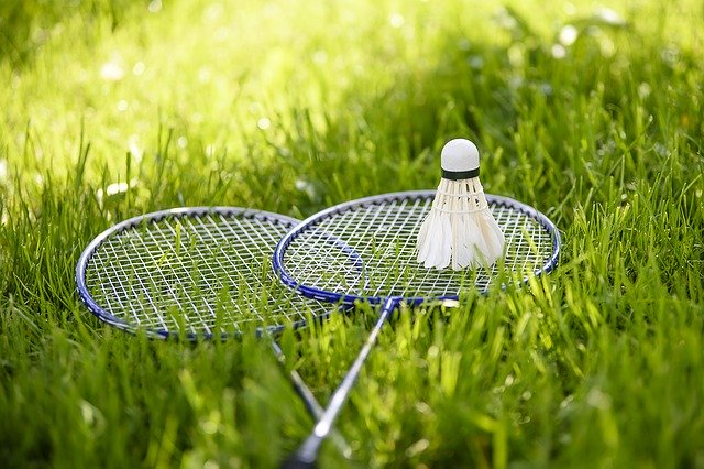 badminton rackets and shuttlecock on lawn