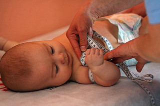 An infant gets measured as part of health check
