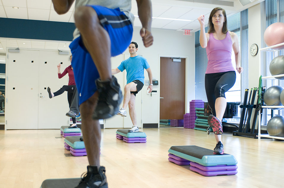 men and women exercising in a class